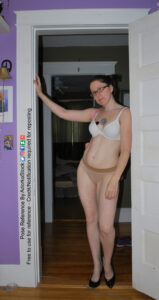woman standing in a door way leaning against it with one hand on the frame