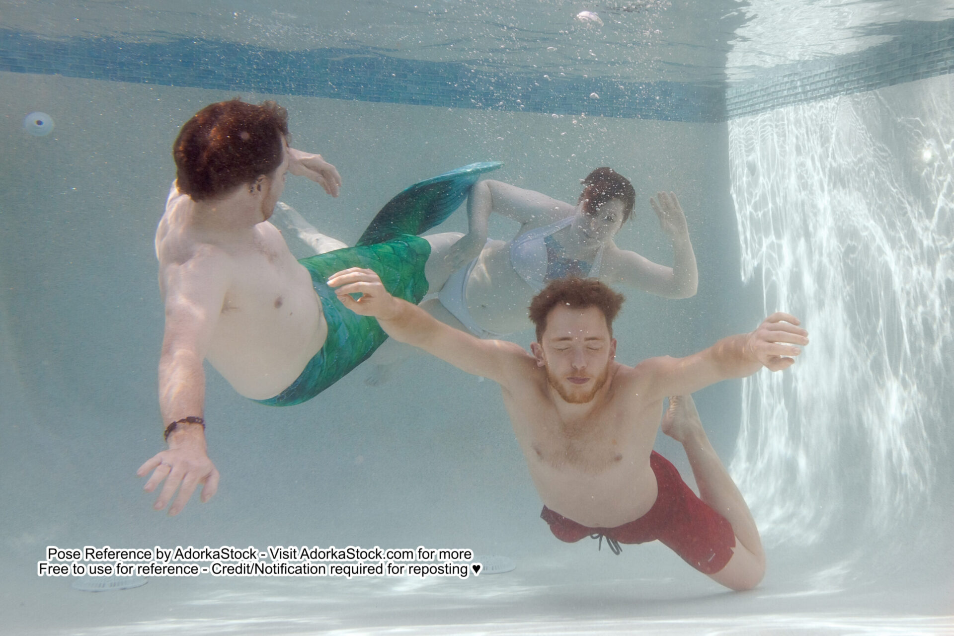 three models underwater in dynamic poses one is wearing a mermaid tail