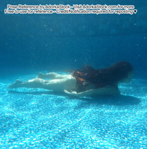 thin Asian female model swimming underwater, arms and legs behind her