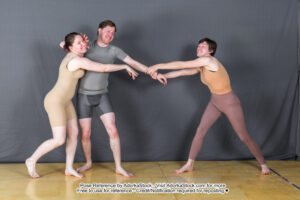 Three models in a physical altercation involving some tugging and pushing between them