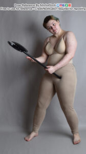 White nonbinary pose reference model holding an ax and looking at it with concern