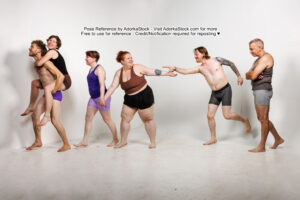 6 models walking in a line, one piggy back, two holding hands, one reaching back, one reaching forward, and the last one with arms folded, falling behind a bit