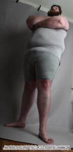 tall fat male model standing with arms crossed shot from a low angle