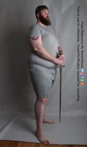 tall fat male model standing in profile with a sword in his hands, tip down by his feet