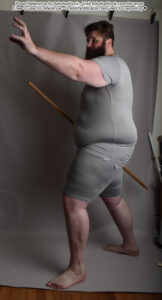fat male model in 3/4 pose with a staff in one hand and the other hand outstretched as if casting a spell