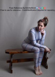 pose reference model in grid suit sitting on a bench looking off to the side with one hand by her face
