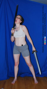 thin white female model holding a sword and licking it