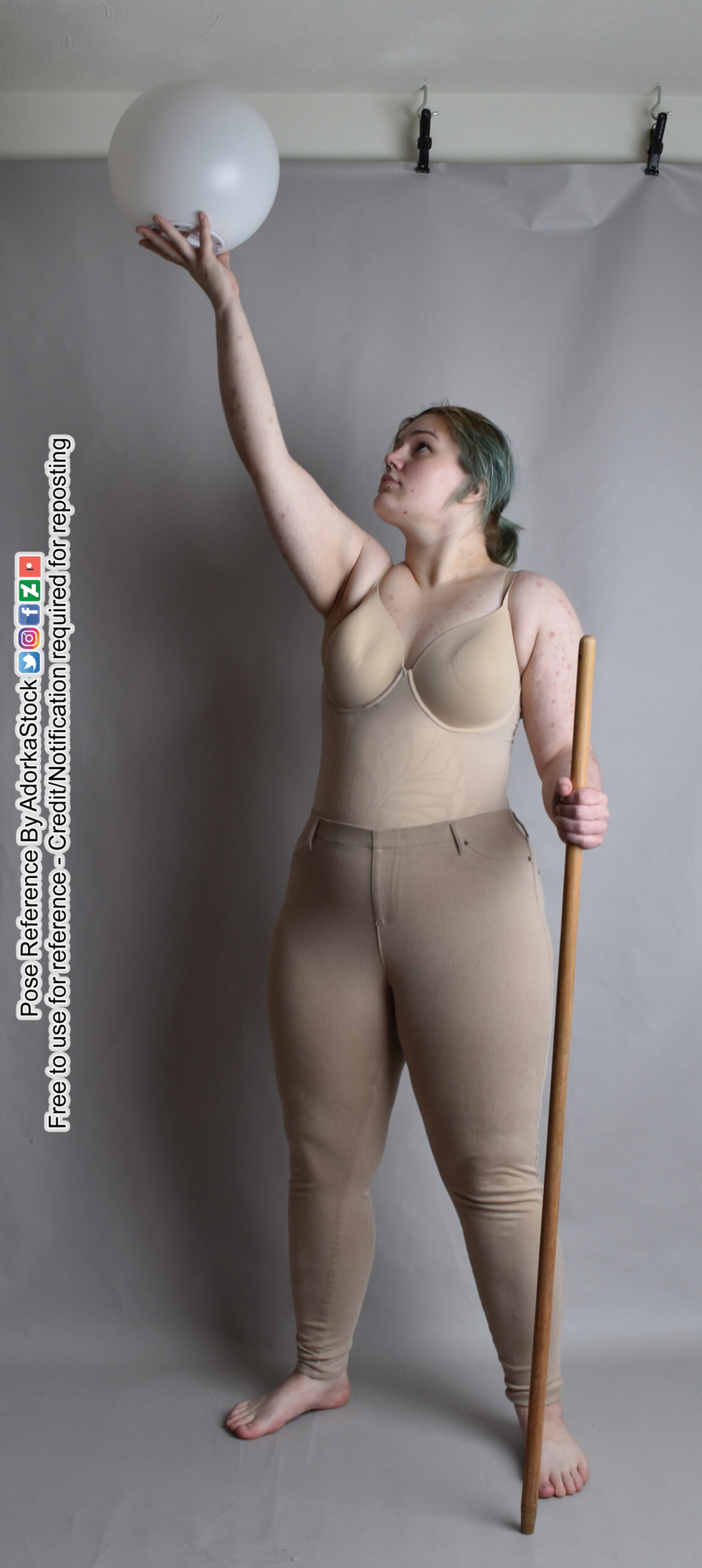 pose reference model standing with a staff in one hand the other raised with a large orb