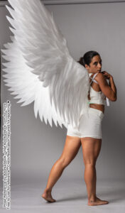fit Latina model facing mostly away with huge white wings looking back over her shoulder