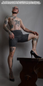 thin, white, male pose reference model in x pose with high heels, one foot up on a bench