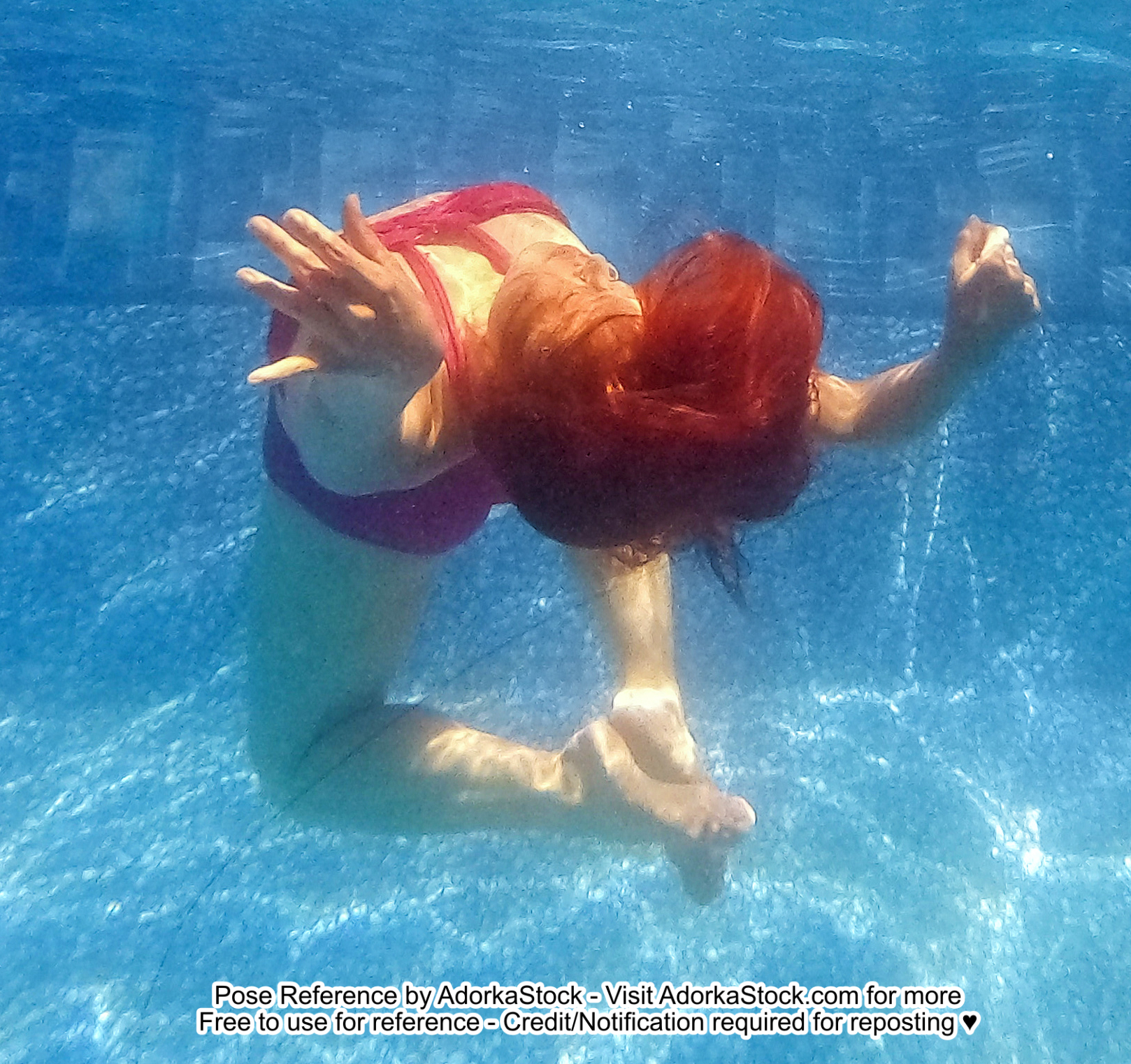 thin Asian female model underwater in a back bend with head and feet towards the camera