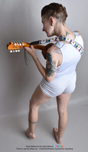 Thin white nonbinary model from a high perspective facing away holding a ukulele