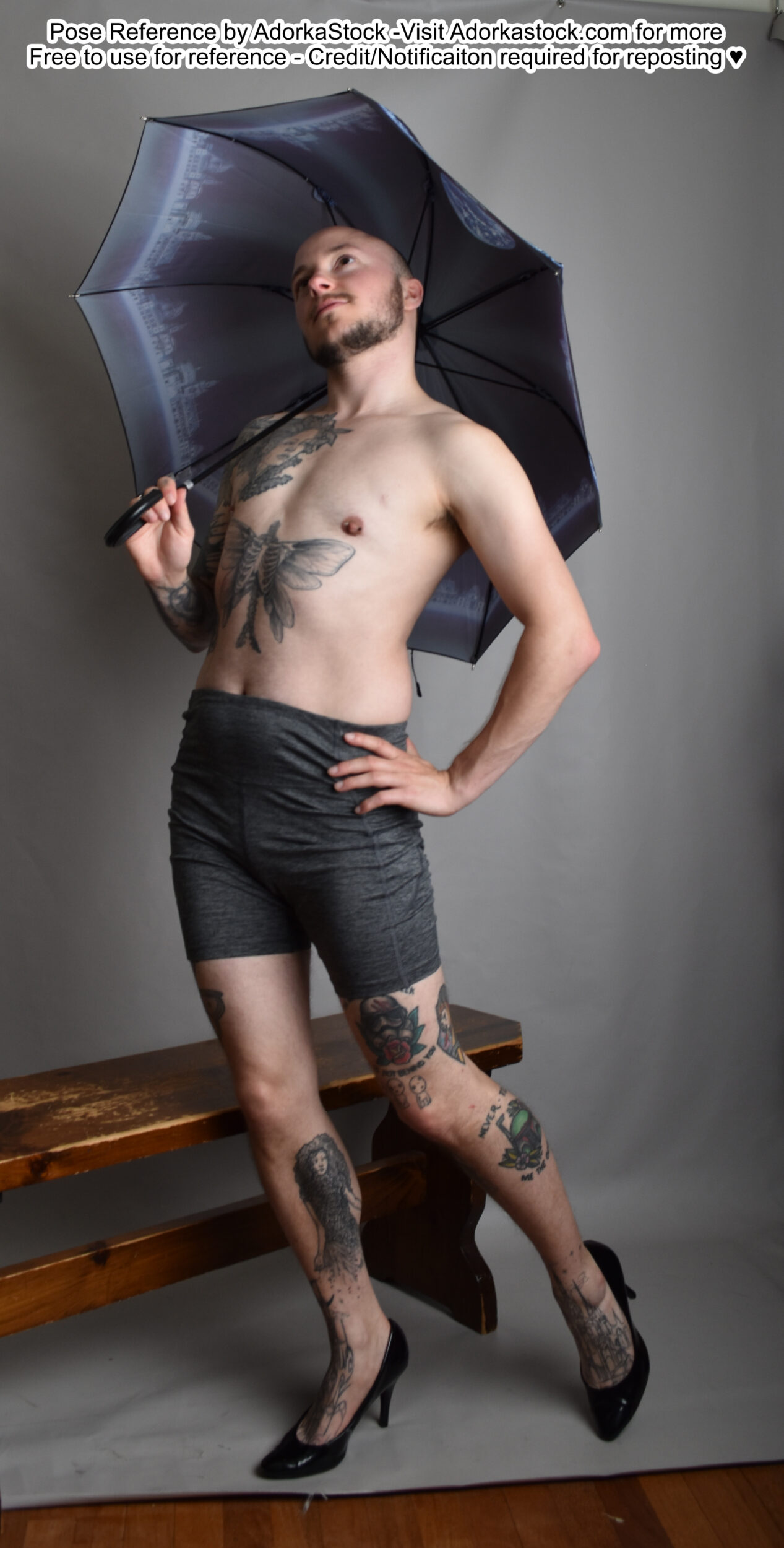 Thin white male model standing in high heels with an umbrella and one hand on a hip
