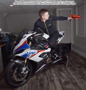 thin white male model sitting on a motorcycle shooting a nerf gun behind him
