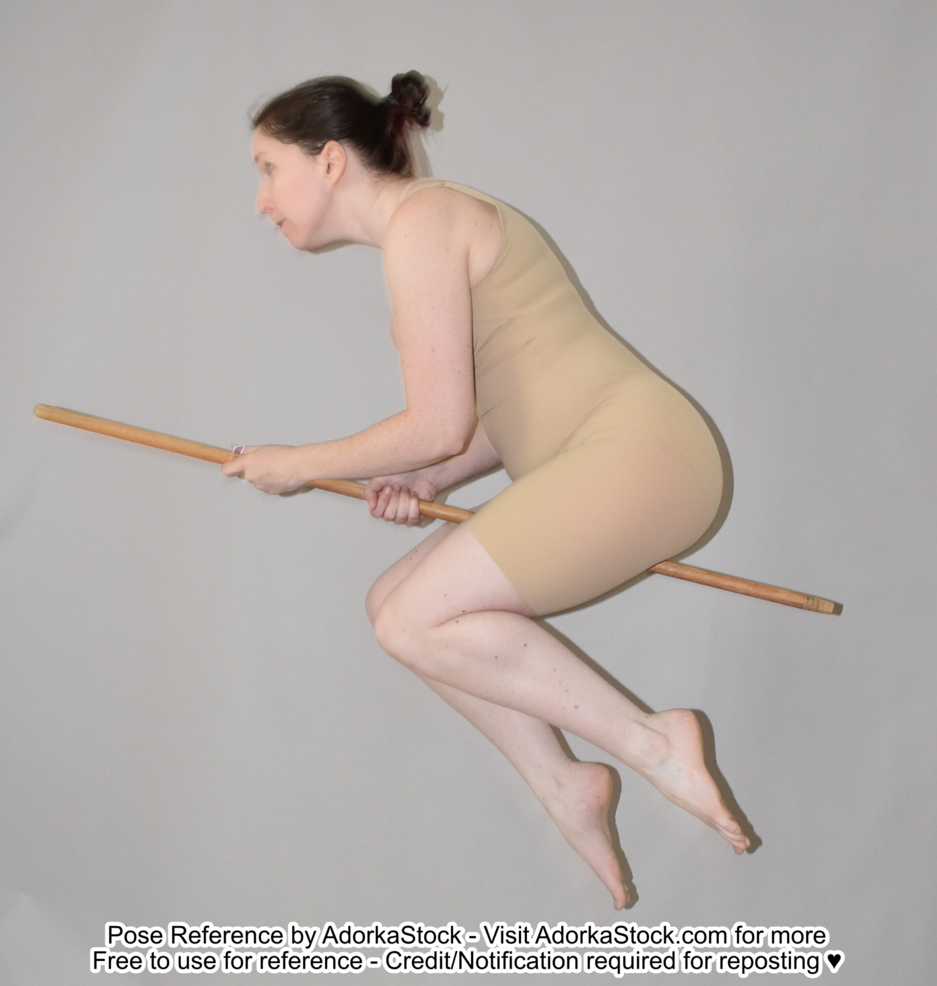 thin white female model in profile riding a staff in the air like a broom
