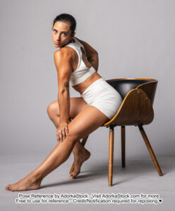 fit Latina model sitting in a chair reaching down to put one hand on her knee