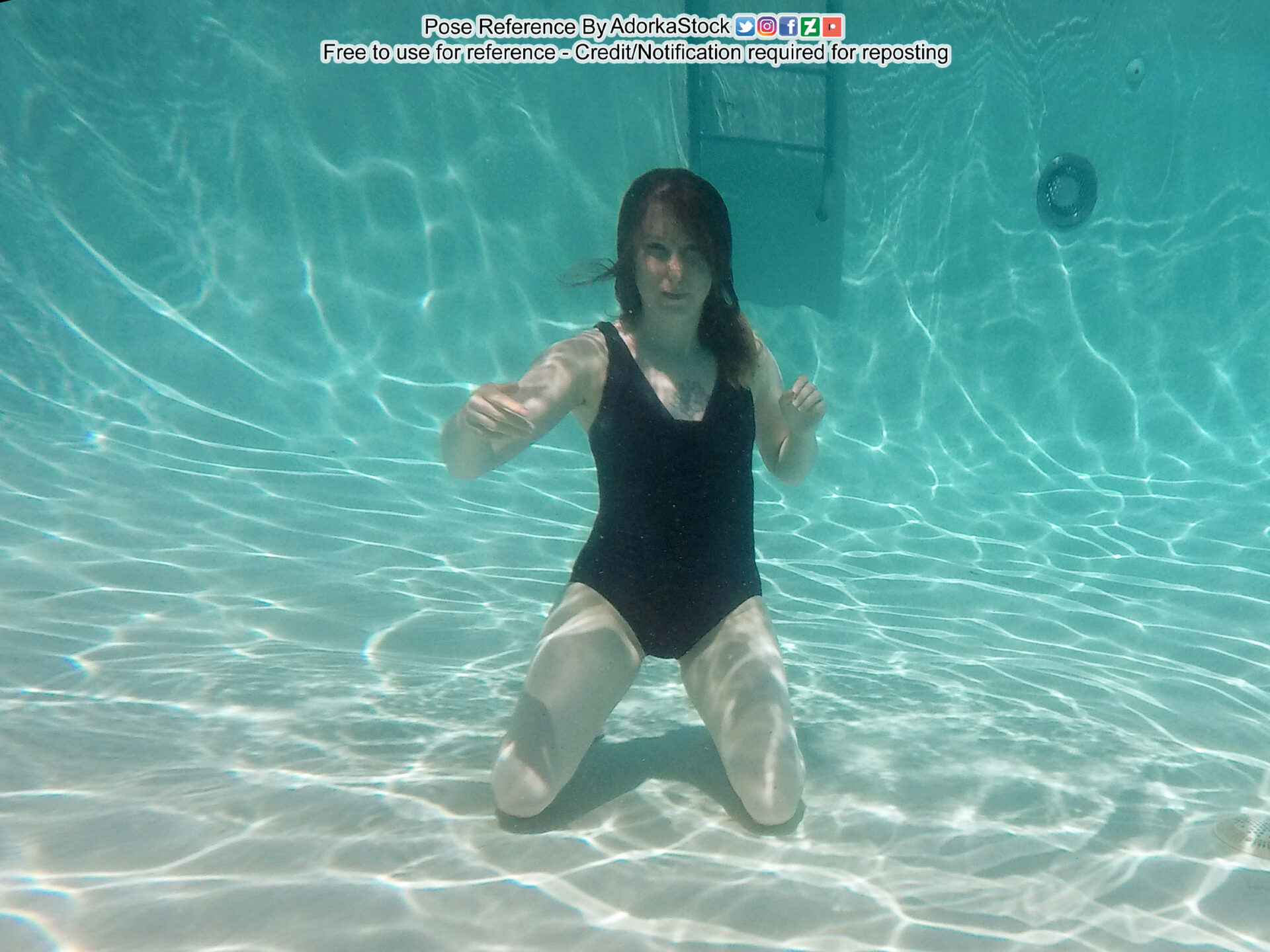 thin white female model kneeling on the floor of a pool with arms loosly floating