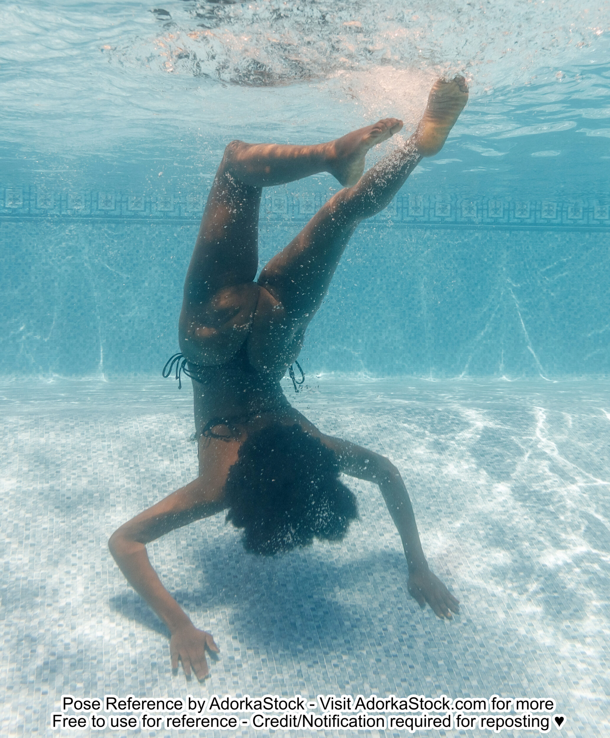 thin tall Black model underwater, head down, feet up, back to the camera