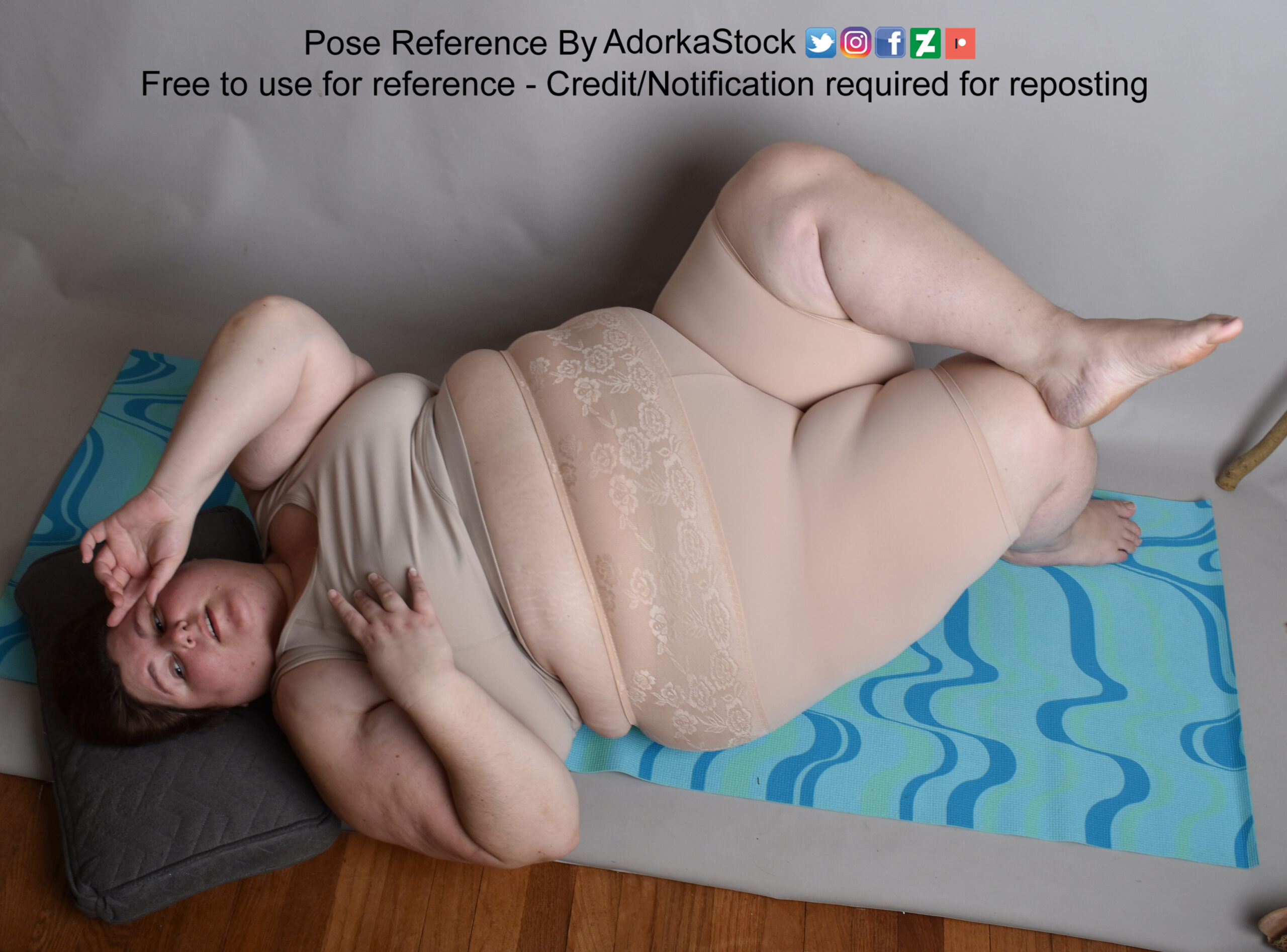 fate white female body lying on the floor seen from above, she has one ankle crossed on the other knee one hand by her face, and the other by her chest
