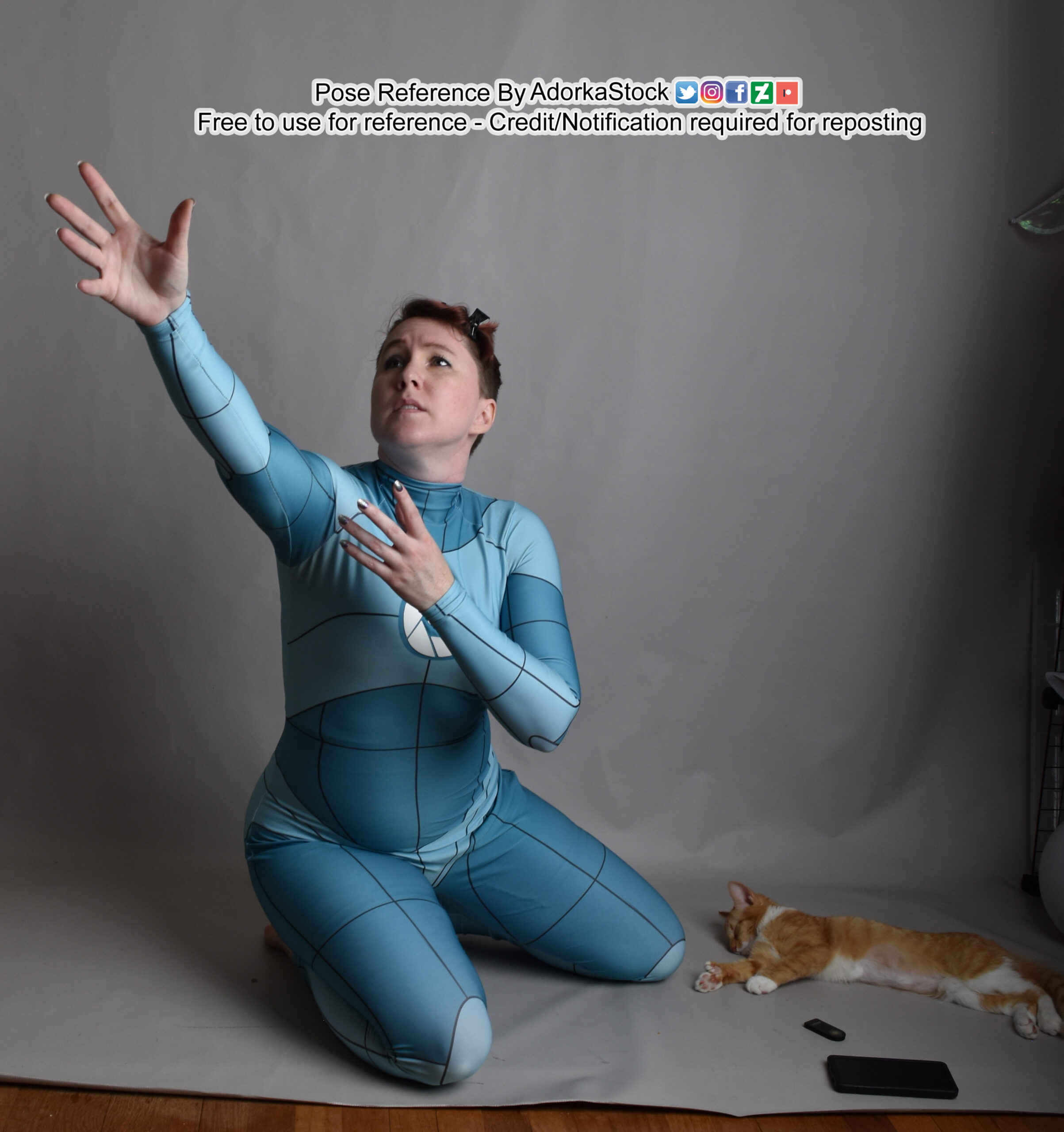 a pose reference of a kneeling thin white female model in grid anatomy suit reaching dramatically to the upper left. THere's also a sleeping kitten on the floor beside her